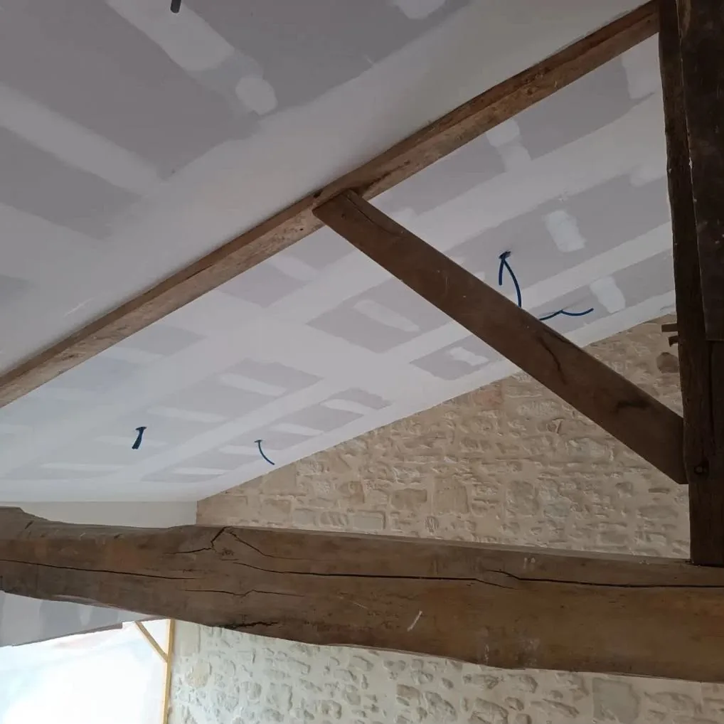 Plafond placo ajusté sur charpente ancienne le long d'un mur en pierre — rénovation de maison ancienne en Lot-et-Garonne